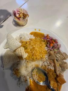a white plate of food with rice and a spoon at Fun Viewpoint Homestay Darjeeling in Darjeeling