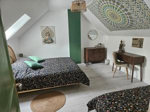 a bedroom with two beds and a desk and a table at Home Gãyatri in Angé