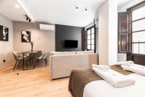 a bedroom with two beds and a dining room with a table at Ando Apartments Boutique in Salamanca