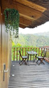 a patio with a table and chairs on a deck at Villa Garcia in Terras de Bouro