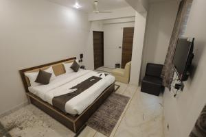a bedroom with a bed and a television in it at Hotel Pearl -Jaipur Pink City Centre in Jaipur