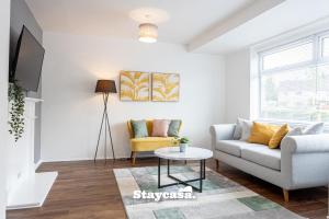 a living room with a couch and a table at Spacious Cosy Cove with Large Driveway and Garden in Wythenshawe