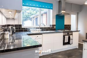 a kitchen with a sink and a dishwasher at Spacious Cosy Cove with Large Driveway and Garden in Wythenshawe