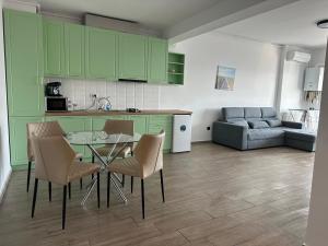 a kitchen with green cabinets and a table and chairs at Grand Panorama Residence in Mamaia