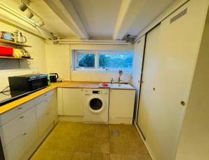 a small kitchen with a washing machine in it at Cozy and Spacious Guest Room, Virum in Virum