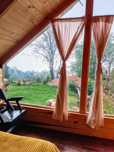 a window in a room with a view of a field at Cabañas Alma Serrana in San Jose del Pacifico