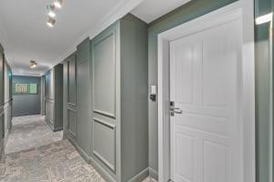 a hallway with green walls and a white door at HOME1 - Lumes Boutique Hotel in Vienna