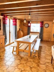 a dining room with a wooden table and benches at O'Doubs Chalet in La Chaux Neuve