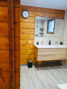 a bathroom with two sinks and a clock on the wall at O'Doubs Chalet in La Chaux Neuve +9 photos