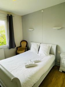 a large white bed with a white towel on it at Le Clos - Proximité plage in Ambleteuse