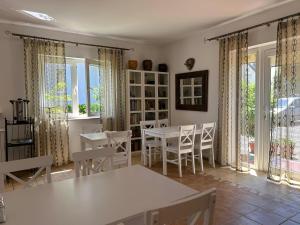 a dining room with white tables and chairs and windows at DG Albatros II in Rewal