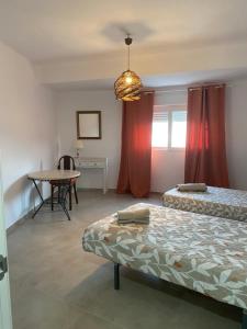 a room with two beds and a table in it at Apartamento con vistas a la Playa con Ascensor y WIFI 9 pax in Daimuz