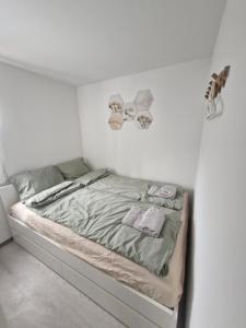 a small bedroom with a bed in a white wall at Cottage house 92 Auqaluna in Podčetrtek