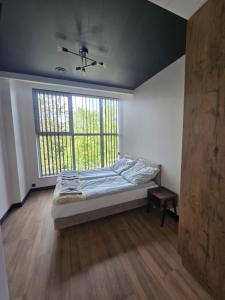 a bedroom with a bed and a large window at TRIO HoSteL in Hajnówka