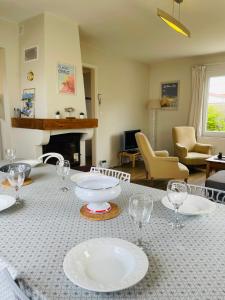 a table with plates and wine glasses on it at Le Clos - Proximité plage in Ambleteuse