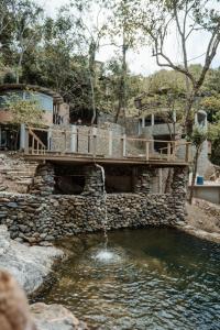a wooden bridge over a pool of water at Ahora Wellness Hostel in Guachaca