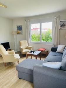 a living room with a blue couch and chairs at Le Clos - Proximité plage in Ambleteuse