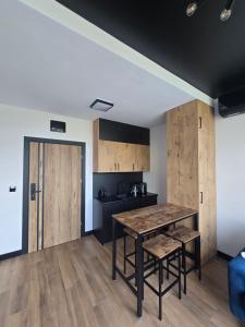 a kitchen with a table and some wooden cabinets at TRIO HoSteL in Hajnówka
