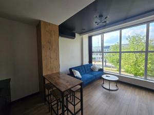 a living room with a blue couch and a table at TRIO HoSteL in Hajnówka