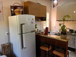 a kitchen with a white refrigerator and a counter at Recanto Miramonti Refúgio com Vista in Cristina