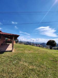 a house on a hill with a green field at Sitio Vale Verde da Serra in Monte Verde