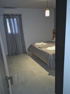 a small bedroom with a bed and a window at Ionian Balcony II in Athani +6 photos