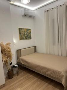 a small bedroom with a bed and a window at Vista Mare Maisonette in Ipsos