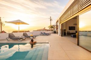 a woman sitting in the pool of a house at Lake House in Calheta