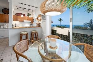 a kitchen and dining room with a glass table and chairs at Kona Mansions#B217 Beautiful unit with Ocean view! in Kailua-Kona