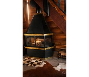 a fireplace in the middle of a room at Chalé do Campinho - Rancho Queimado/SC in Rancho Queimado