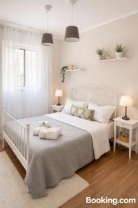 a white bedroom with a white bed and two lamps at Lùrooms- Guesthouse in Noto in Noto