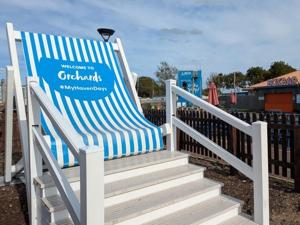a blue and white beach chair sitting on the stairs at Holiday Caravan Orchards Holiday Village in Brightlingsea