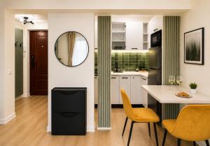 a kitchen with a table and chairs and a mirror at Victoriei Studio Old City in Bucharest