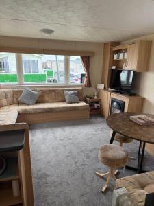 a living room with a couch and a table at Holiday Caravan Orchards Holiday Village in Brightlingsea