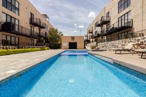 a swimming pool in front of two apartment buildings at Oasis privado en Querétaro in Alvarado