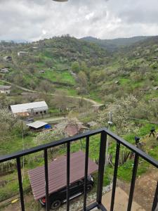 a balcony with a view of a hill with a truck at Hyuratun Lori