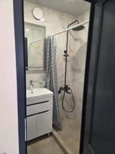 a bathroom with a sink and a shower with a shower curtain at Hyuratun Lori