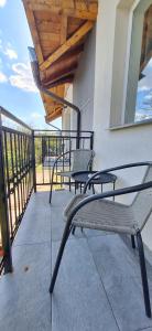 a patio with two chairs and a table on a balcony at Vila Armonia in Curtea de Argeş