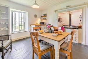 a kitchen with a wooden table and chairs at 3 Bed in Lostwithiel oc-cwhite in Saint Winnow +22 photos