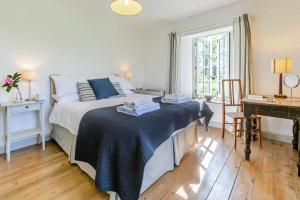 a bedroom with a bed with a blue blanket on it at 3 Bed in Lostwithiel oc-cwhite in Saint Winnow