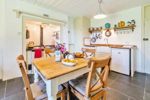a kitchen and dining room with a wooden table and chairs at 3 Bed in Lostwithiel oc-cwhite in Saint Winnow