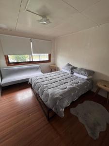 a bedroom with a large bed and a window at Casa Maya Modern central and pet friendly in Futaleufú +7 photos