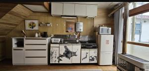 a kitchen with a stove and a refrigerator at The Lodge In Sapporo in Sapporo +8 photos