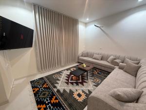 a living room with a couch and a table at استديو كلاود غرفتين نوم in Al Baha