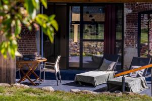 a patio with two chairs and a table and a table and chairs at Wellnesshoeve in Boutersem +5 photos