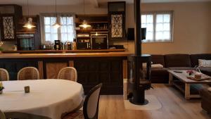 a kitchen and a living room with a table and chairs at Gîte Nid dans la Forêt in Saint-Jean-aux-Bois