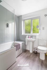 a white bathroom with a sink and a toilet at Spacious 2BR Home w Garden 2-Min Walk to Town in Stockport +23 photos