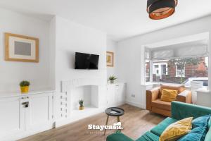 a living room with a couch and a fireplace at Spacious 2BR Home w Garden 2-Min Walk to Town in Stockport