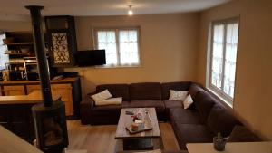 a living room with a couch and a table at Gîte Nid dans la Forêt in Saint-Jean-aux-Bois
