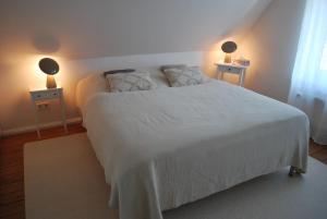a bedroom with a white bed with two night stands at Friesen-Cottage in Friedrichstadt